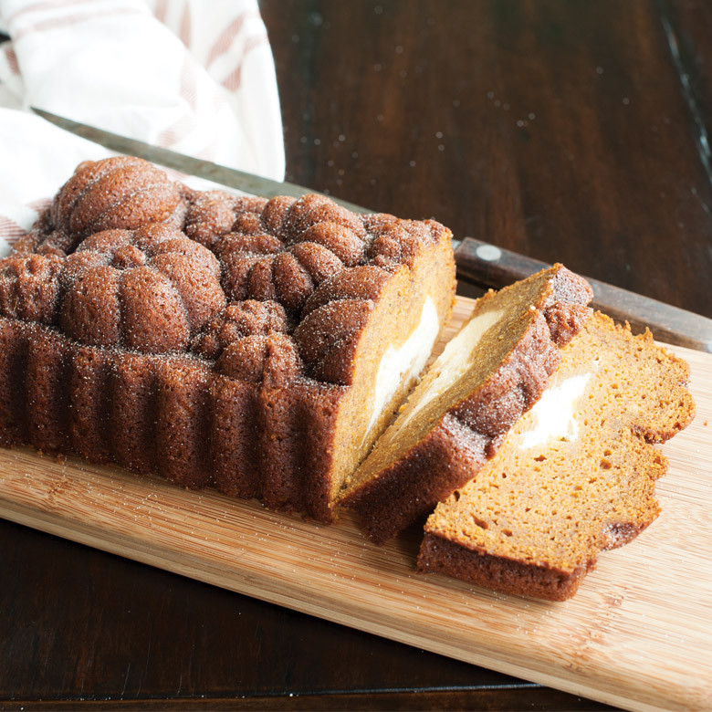 Sliced pumpkin loaf with cream cheese filling baked in Nordic Ware Harvest Bounty pan, showing detailed autumn leaf design