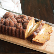 Sliced pumpkin loaf with cream cheese filling baked in Nordic Ware Harvest Bounty pan, showing detailed autumn leaf design