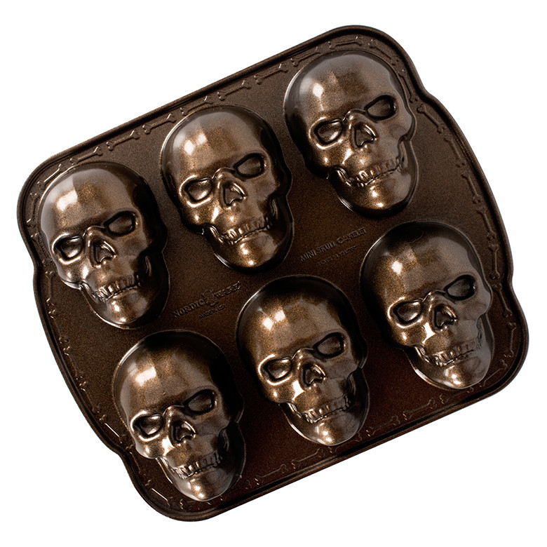 Nordic Ware cast aluminum haunted skull cakelet pan with 6 detailed skull-shaped cavities, dark gray finish