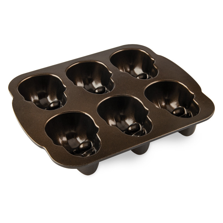Nordic Ware Haunted Skull Cakelet Pan showing 6 detailed skull-shaped cavities with bronze nonstick interior coating