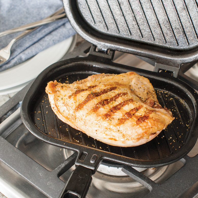 Nordic Ware stovetop grill press with grilled chicken breast, cast aluminum with ridged cooking surface
