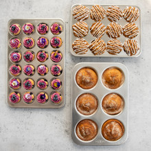 Three Nordic Ware Naturals aluminum muffin pans: 24-cavity petite, jumbo 6-cavity, and standard 12-cavity