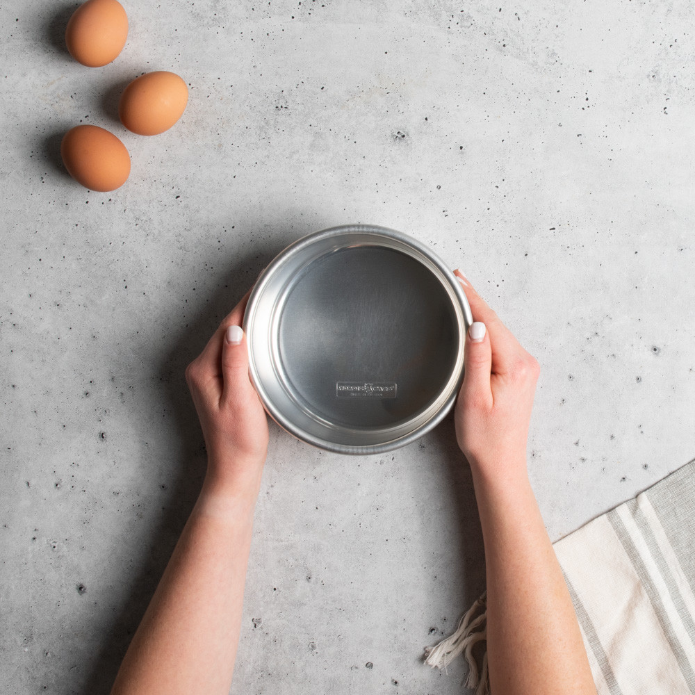 hands grabbing nordic ware 6in layer cake pan