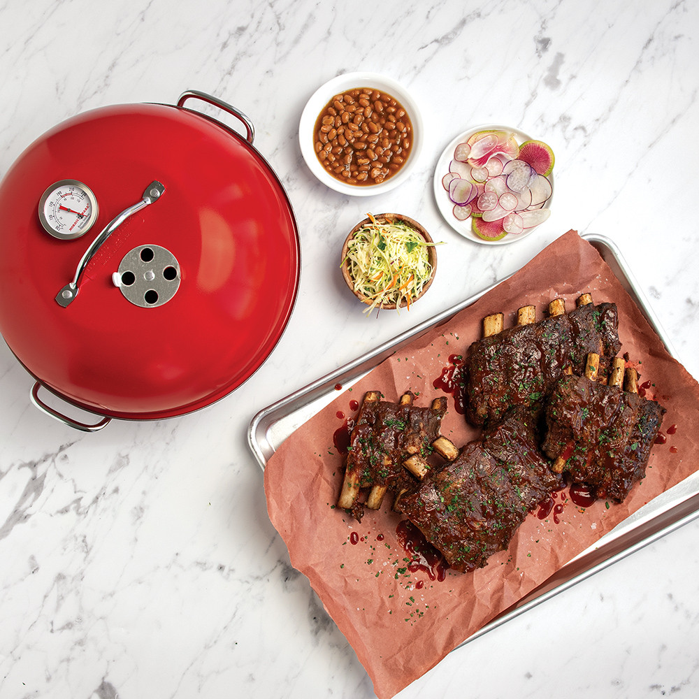 Overhead image of smoked ribs on a sheet pan with Indoor/Outdoor Kettle Smoker on the side