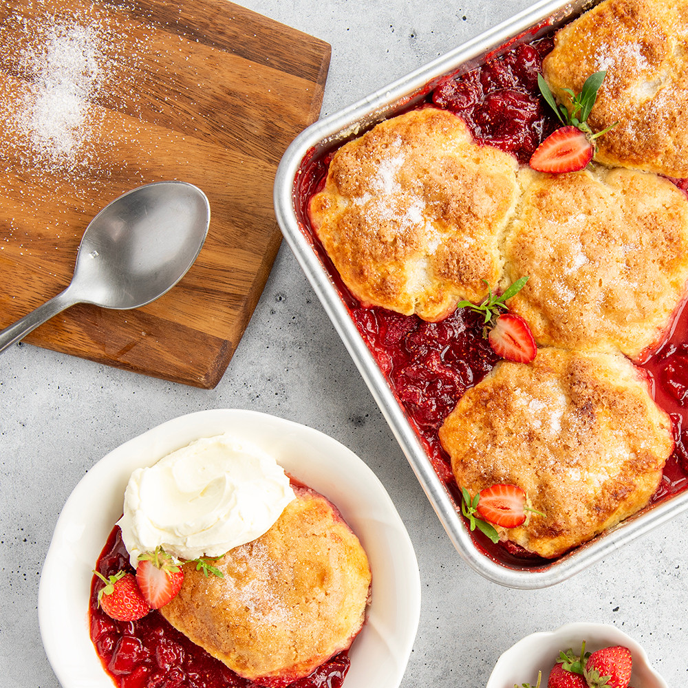 Nordic Ware aluminum square cake pan with golden fruit crisp and single serving on white plate