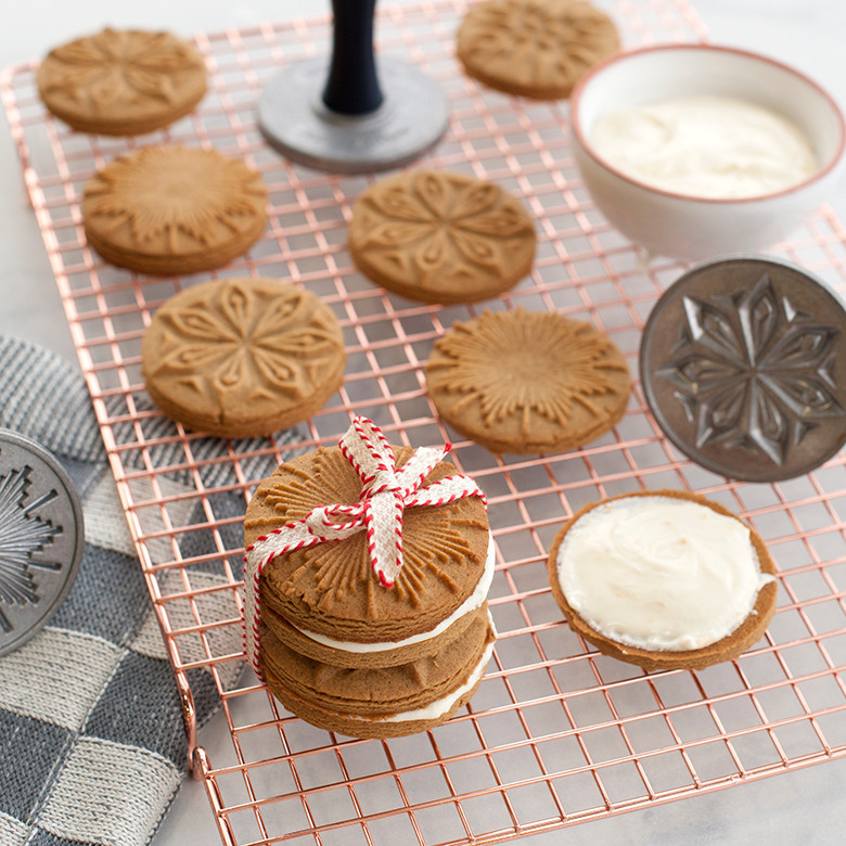 Freshly baked decorated cookies cooling on Nordic Ware large copper-plated wire cooling rack
