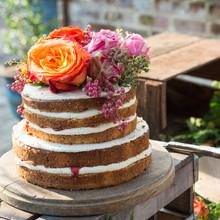 Three-layer vanilla cake with white frosting and fresh flowers, baked using Nordic Ware round cake pans