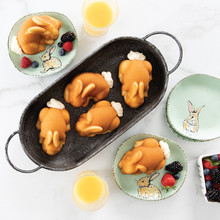 Golden-brown bunny-shaped cakes from Nordic Ware Baby Bunny pan arranged in wicker basket with plated fruit