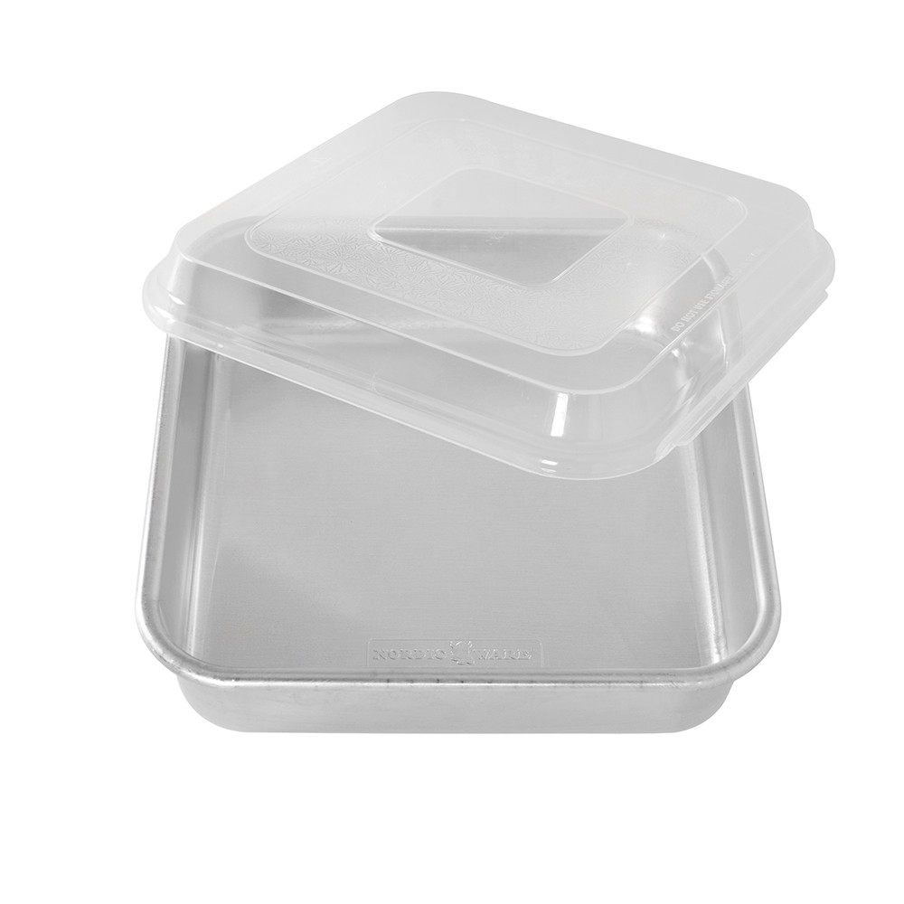 Nordic Ware aluminum square cake pan with clear plastic lid partially removed, natural silver finish