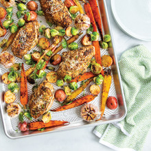 Roasted chicken and colorful vegetables on Nordic Ware Prism aluminum baking sheet, golden brown and caramelized