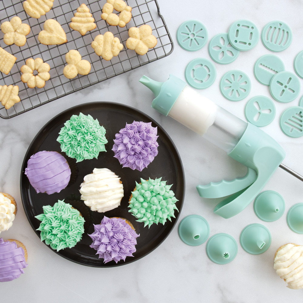 Decorated cupcakes with piped frosting and golden spritz cookies made with Nordic Ware cookie press discs