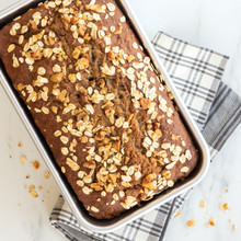 Golden baked banana bread loaf in Nordic Ware aluminum loaf pan, natural finish, rectangular shape