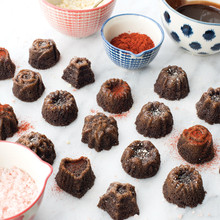 Six chocolate mini bundt cakes with colorful sprinkles baked in Nordic Ware tea cakes pan on white counter