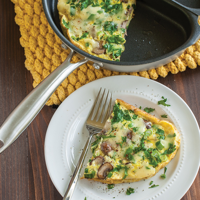 Nordic Ware aluminum frittata pan with golden cooked frittata, black non-stick interior, silver exterior
