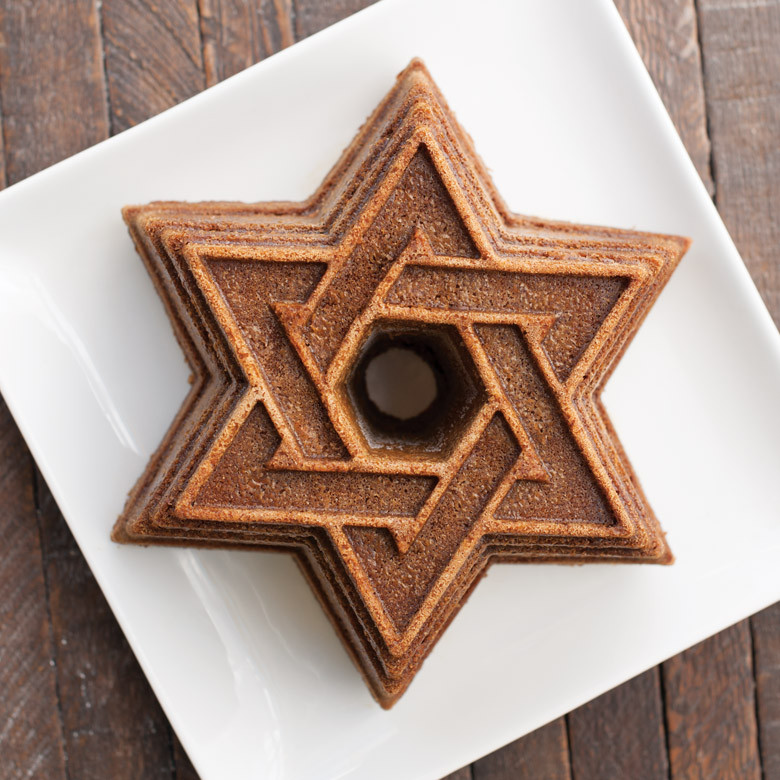 Golden cinnamon bundt cake baked in Nordic Ware Star of David pan, showing six-pointed star pattern with fluted edges