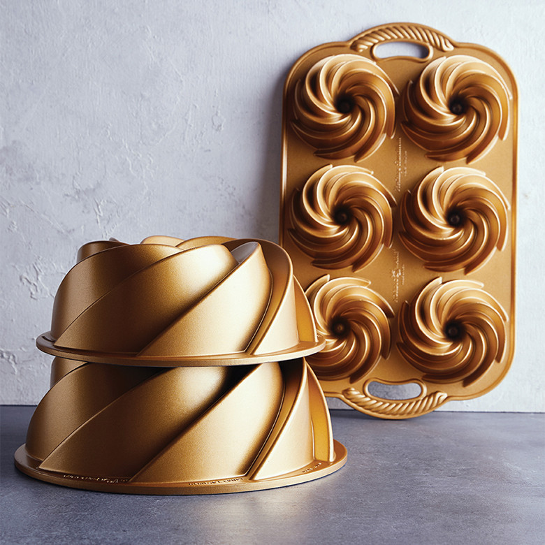Three Nordic Ware Heritage bundt pans in different sizes: large 10-cup, medium 6-cup, and mini bundtlette pan with intricate fluted aluminum design