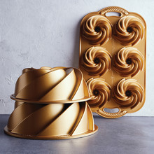 Three Nordic Ware Heritage bundt pans in different sizes: large 10-cup, medium 6-cup, and mini bundtlette pan with intricate fluted aluminum design