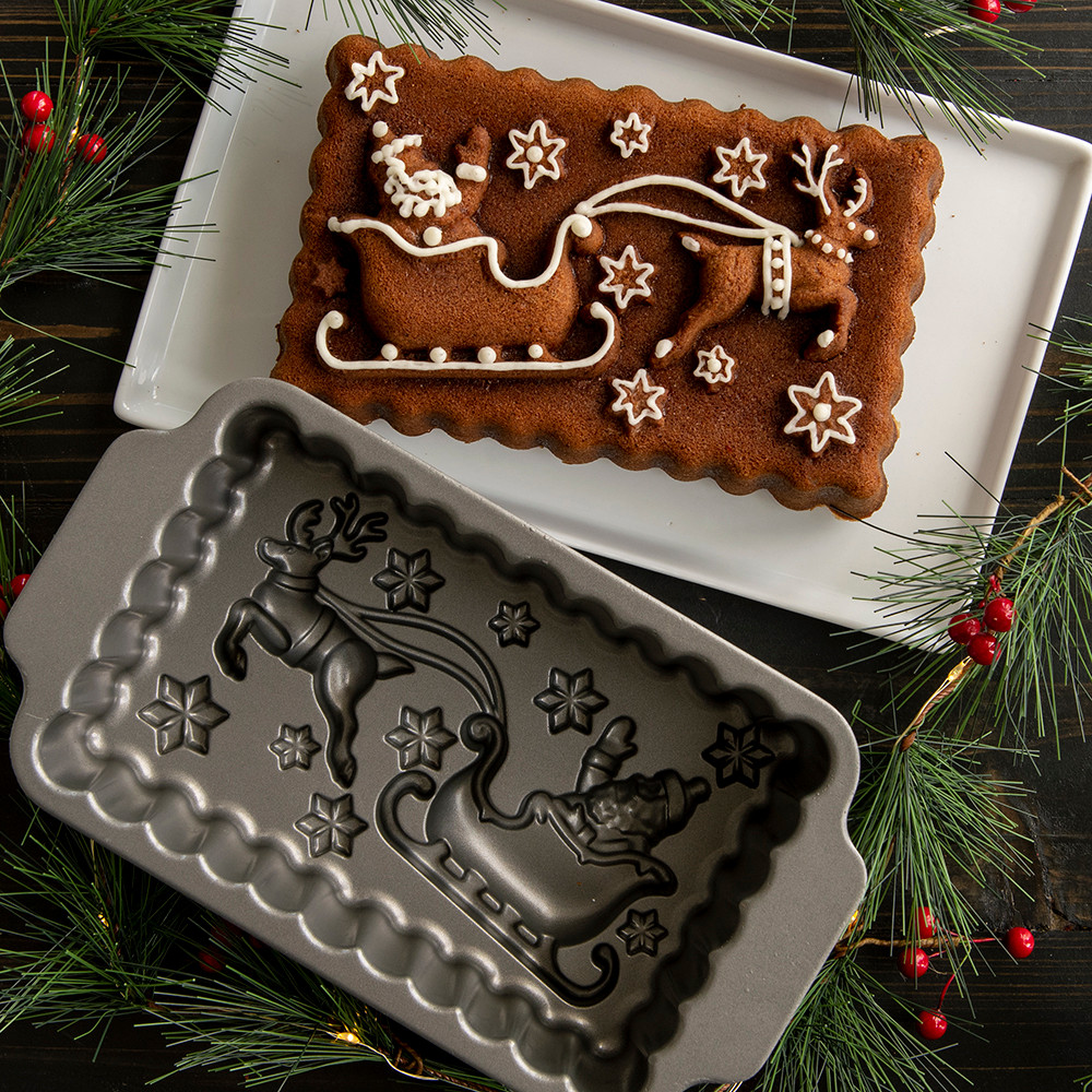 Nordic Ware Santa's Sleigh aluminum loaf pan with golden-brown baked bread, detailed sleigh design with runners