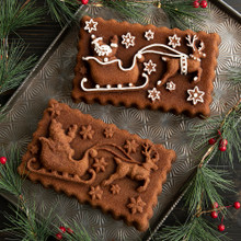 Baked gingerbread loaf shaped like Santa's sleigh with red and white icing details from Nordic Ware pan