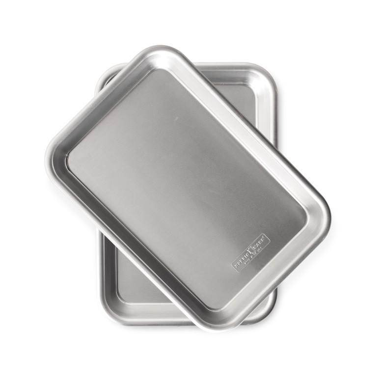 Two Nordic Ware aluminum eighth sheet pans with raised rims and built-in handles, natural silver finish