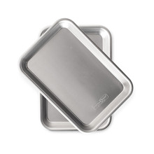 Two Nordic Ware aluminum eighth sheet pans with raised rims and built-in handles, natural silver finish