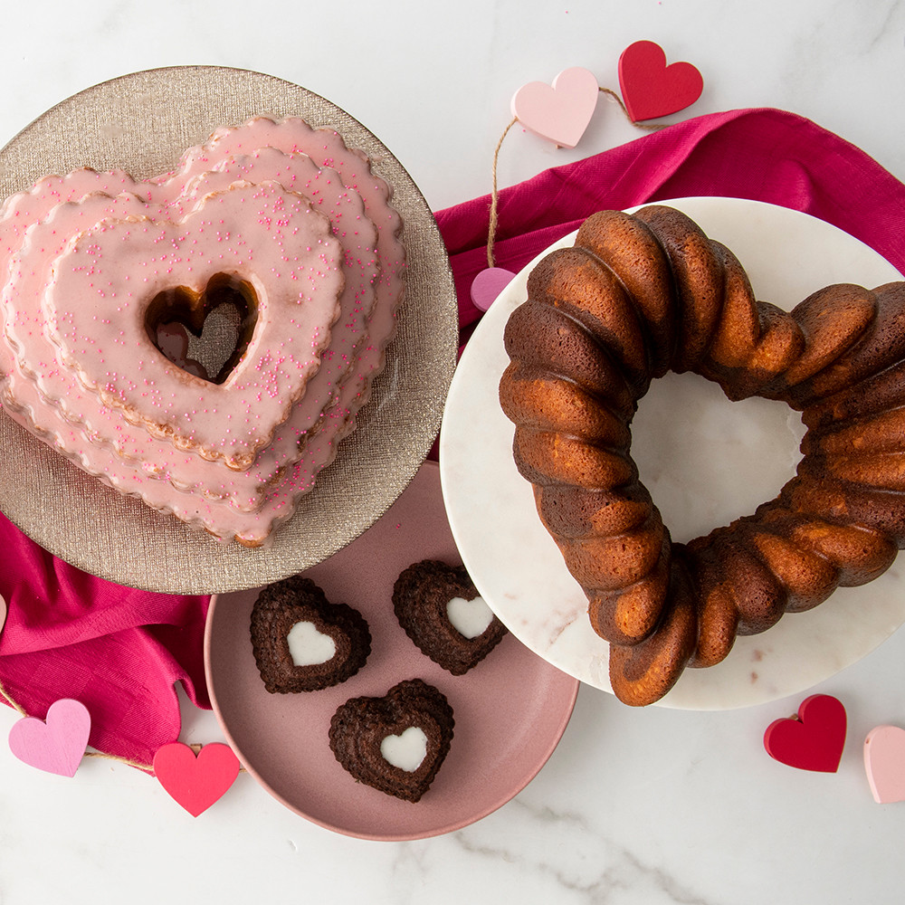Pink frosted heart cake and golden bundt heart cake from Nordic Ware tiered heart cakelet pan with chocolates