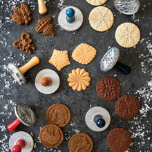Nordic Ware Yuletide cookie stamps with baked golden and chocolate cookies showing holiday patterns