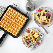 Nordic Ware stovetop Belgian waffler with golden waffle inside, two plated waffles topped with butter and berries