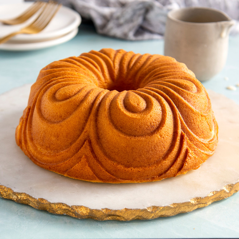 Golden chiffon bundt cake from Nordic Ware pan, showing elegant swirled pattern design on white plate