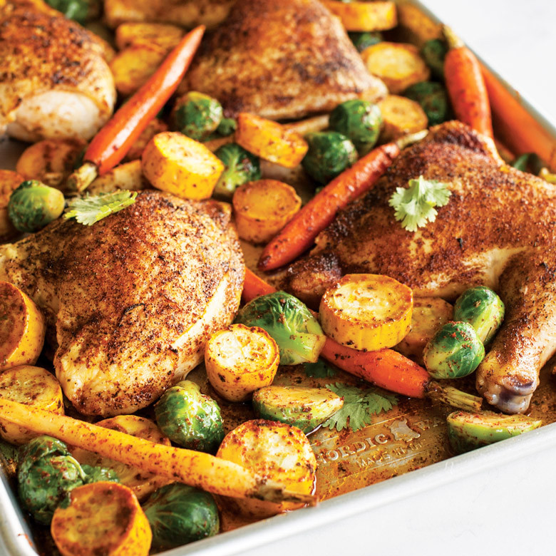 Golden-brown spiced chicken thighs with roasted vegetables on Nordic Ware aluminum big sheet baking pan