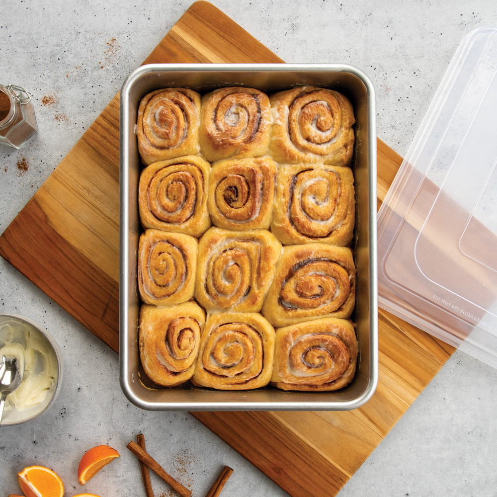 nordic ware 9x13 rectangular cake pan with lid filled with cinnamon rolls