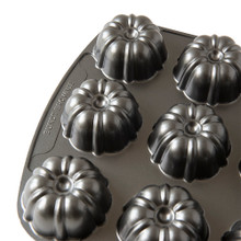 Nordic Ware aluminum bundt brownie pan with six individual fluted cavities, bronze non-stick finish