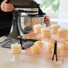 Nordic Ware copper stackable cooling grids with vanilla cupcakes, wire mesh design with black support legs