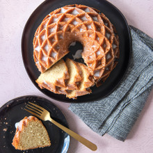 Golden glazed bundt cake with decorative diamond pattern from Nordic Ware Jubilee pan, one slice removed