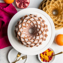 Nordic Ware gold aluminum Jubilee bundt pan with glazed cake showing geometric diamond pattern design