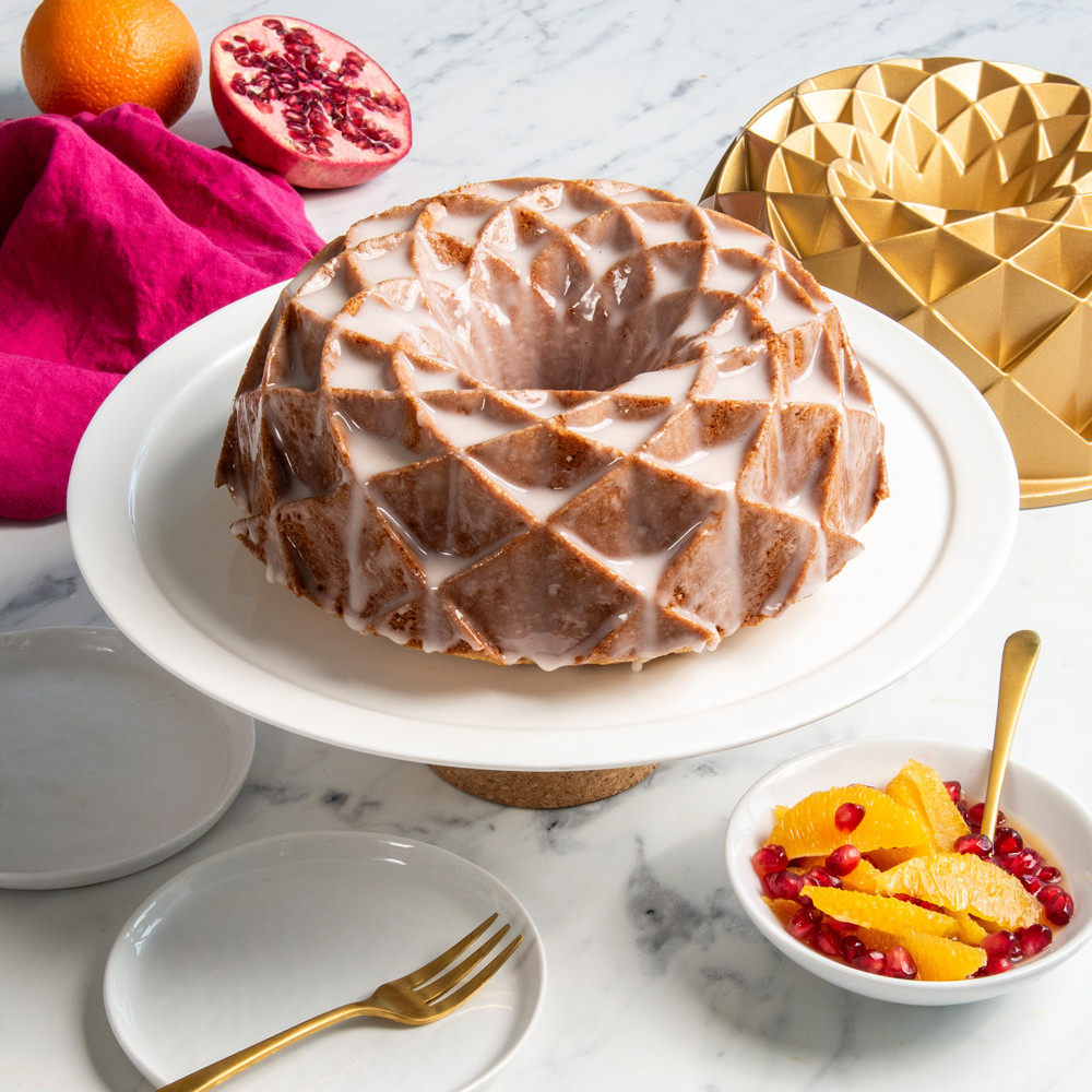 Nordic Ware gold aluminum Jubilee bundt pan with glazed cake showing geometric diamond pattern design