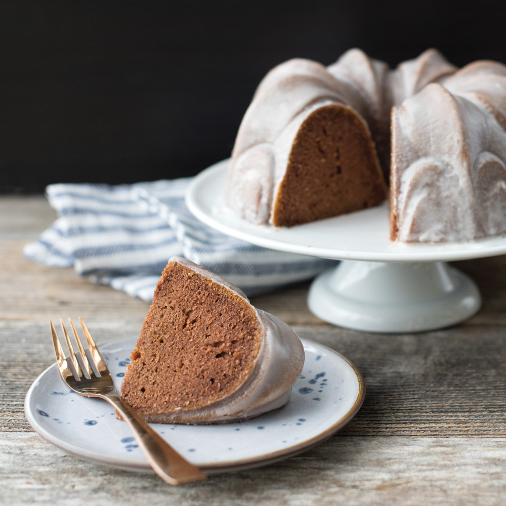 Golden bundt cake with white glaze baked in Nordic Ware Fleur-de-Lis pan, showing fluted petal design