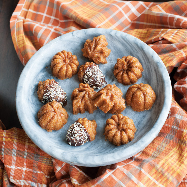 Nordic Ware aluminum cakelet pan with baked pumpkin-shaped cakes, some dusted with powdered sugar