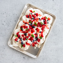 Nordic Ware aluminum jelly roll pan with pavlova topped with whipped cream, strawberries, and blueberries
