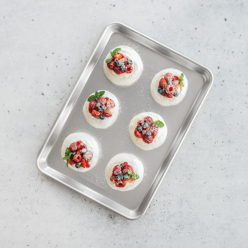 Nordic Ware aluminum jelly roll pan with pavlova topped with whipped cream, strawberries, and blueberries