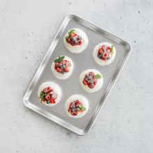 Nordic Ware aluminum jelly roll pan with pavlova topped with whipped cream, strawberries, and blueberries