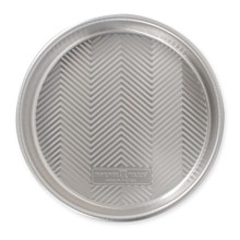 Nordic Ware aluminum 9-inch round cake pan with geometric chevron pattern on bottom, silver finish