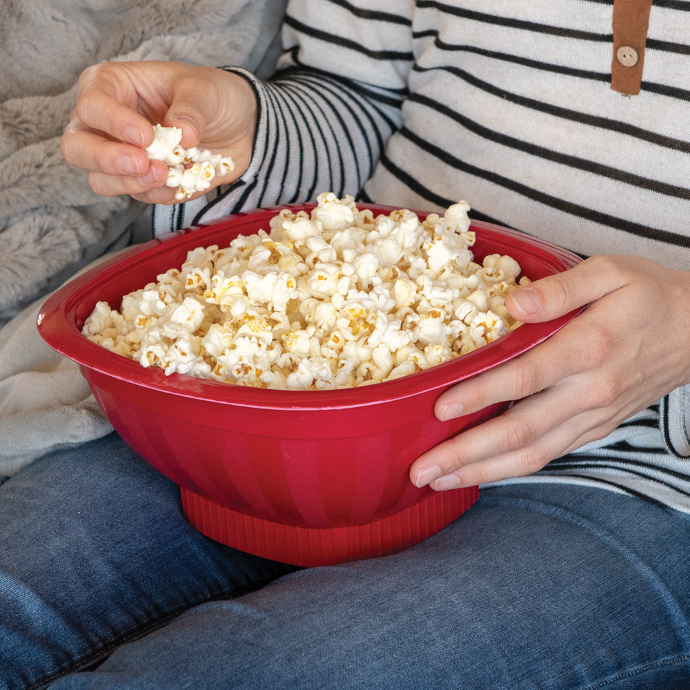 Person holding Nordic Ware red Pro Pop microwave popcorn popper filled with fresh white popcorn