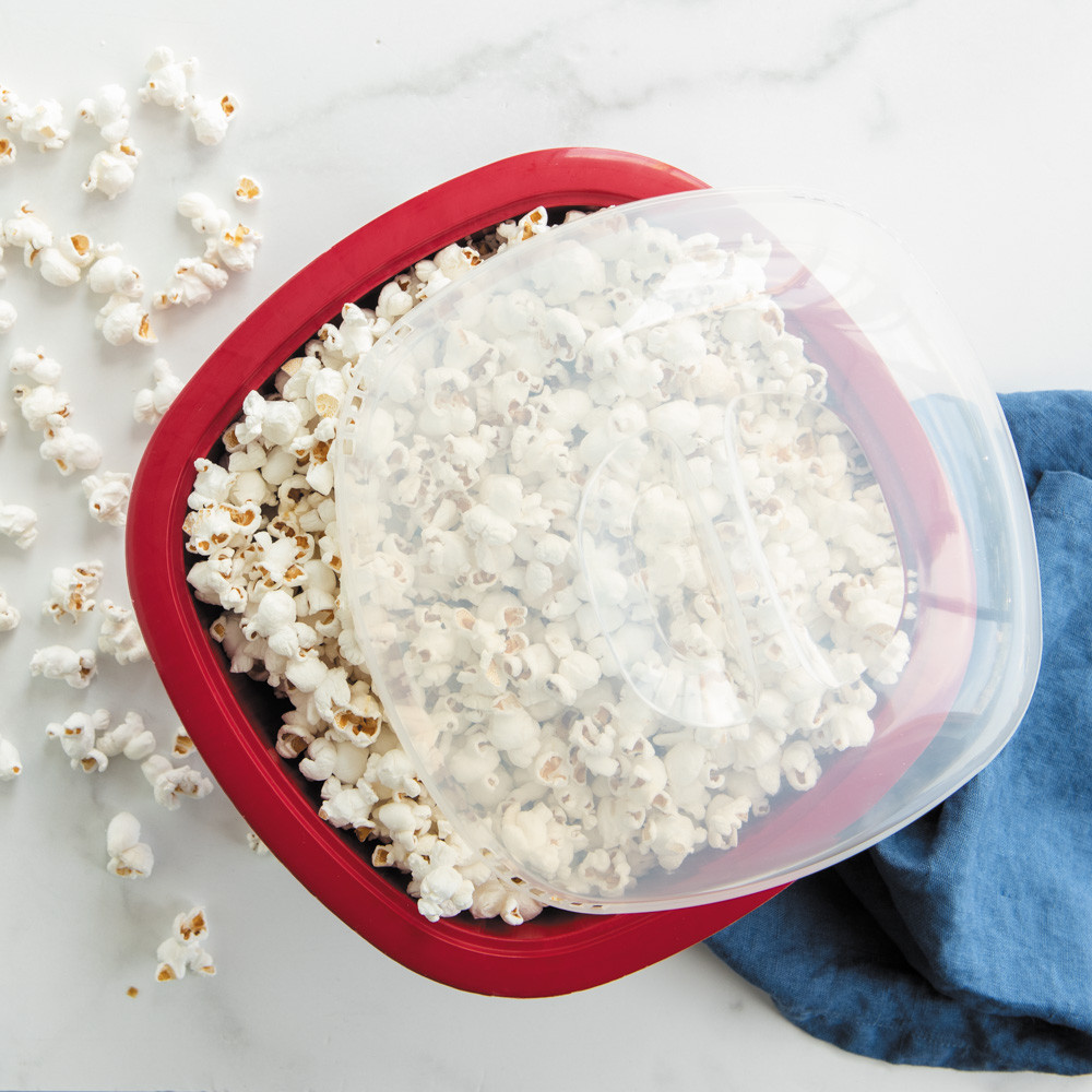 Nordic Ware red Pro Pop Popper bowl filled with freshly popped white and yellow popcorn kernels