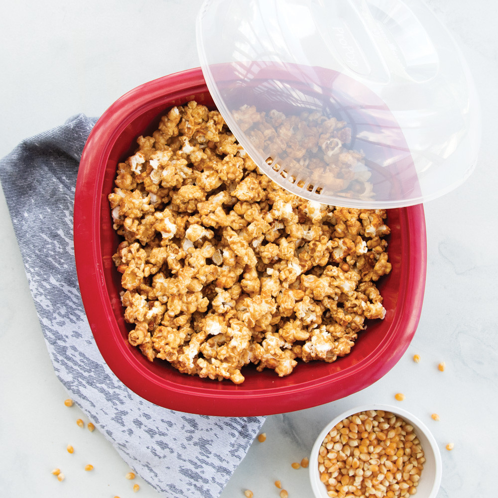 Nordic Ware red Pro Pop Popper bowl filled with freshly popped cinnamon flavored popcorn