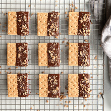 Chocolate-dipped shortbread cookies with chopped nuts cooling on Nordic Ware wire grid rack