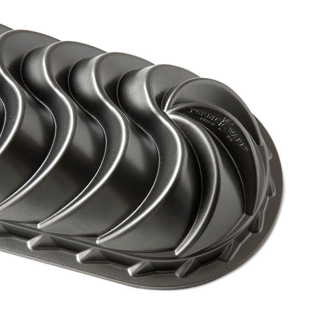 Nordic Ware Heritage aluminum loaf pan with decorative swirled exterior pattern, dark bronze finish