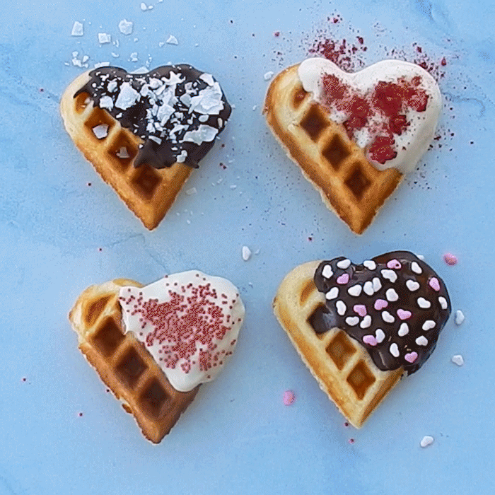 Nordic Ware Sweetheart Waffler making golden heart-shaped waffles, red cast aluminum waffle maker