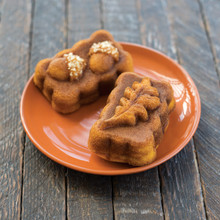 Two golden-brown mini spice loaves on white plate, baked in Nordic Ware Harvest mini loaf pan with chopped nuts
