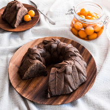 Chocolate bundt cake with detailed leaf pattern from Nordic Ware Harvest Leaves pan, dusted with powdered sugar, slice on side plate